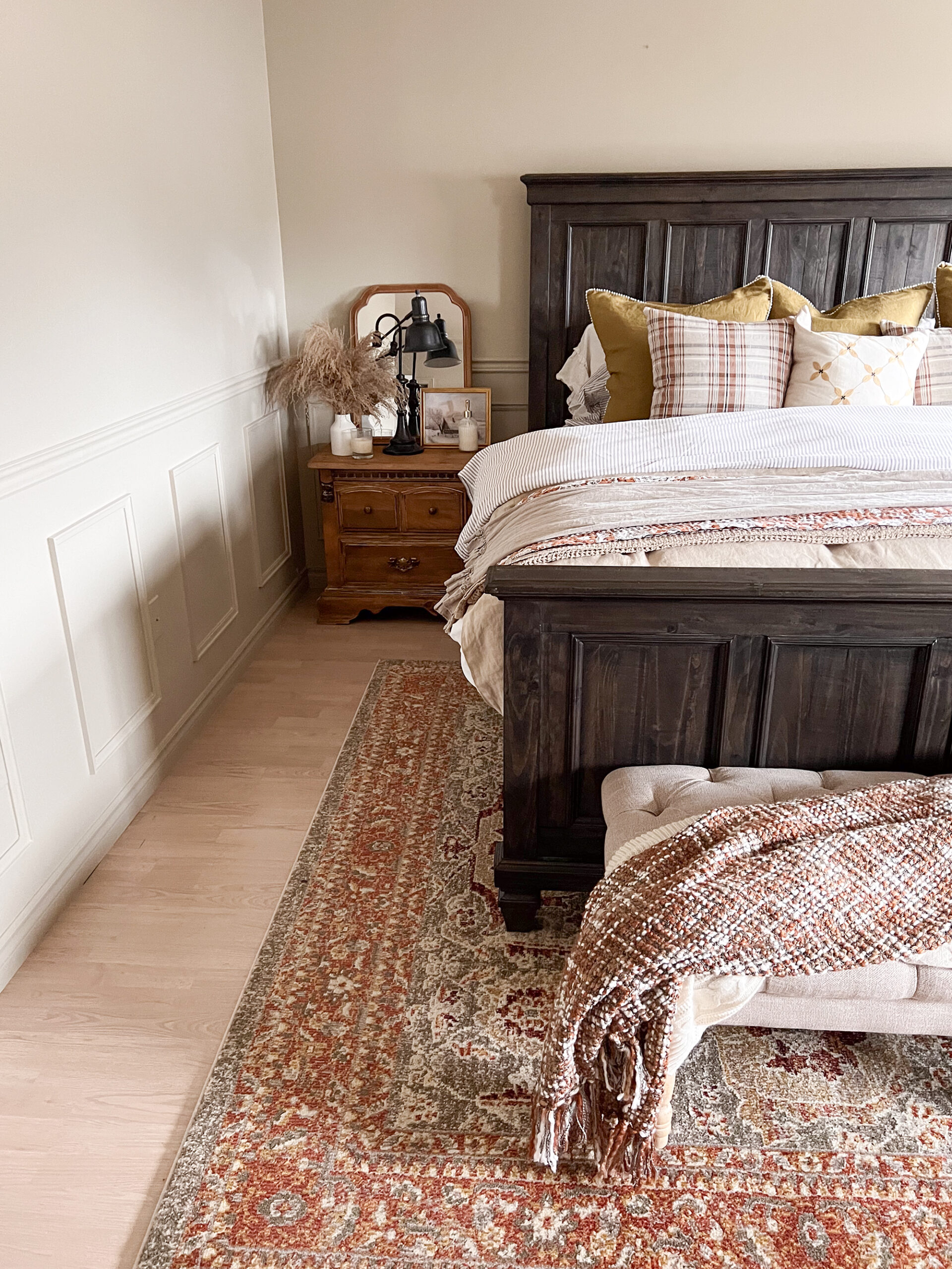 bedroom with king size farmhouse style bed and wood nightstand
