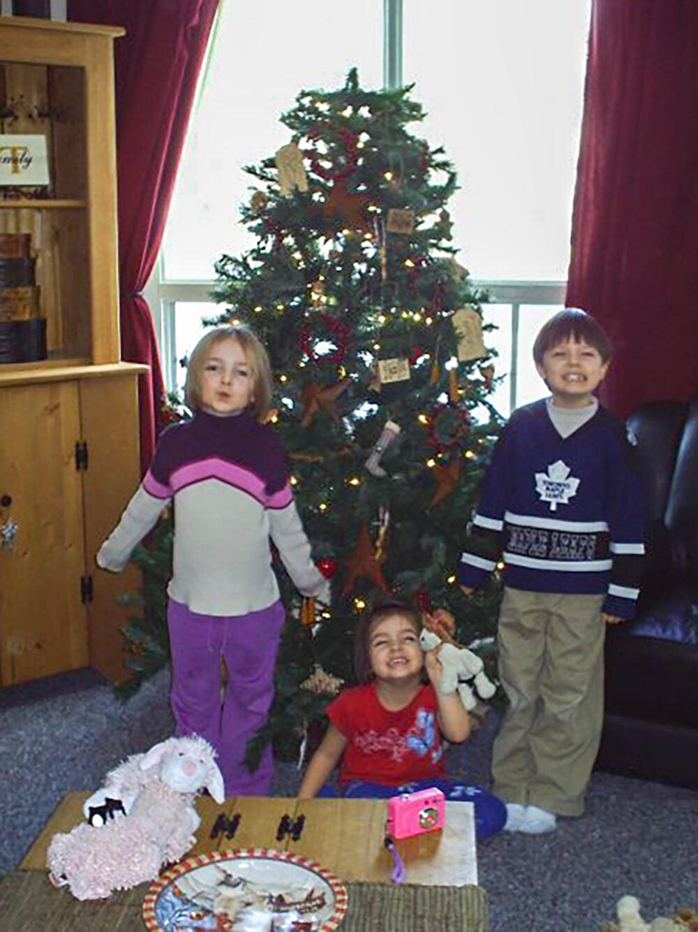 my little kids by the tree to illustrate ways to practice gratitude this christmas