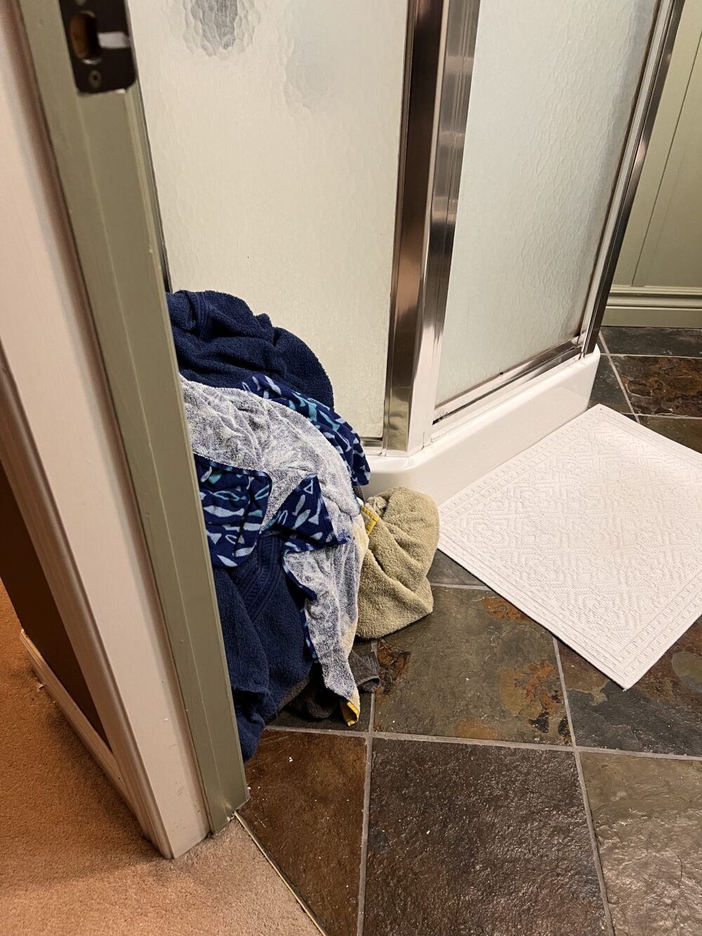 pile of dirty laundry in the bathroom with no basket
