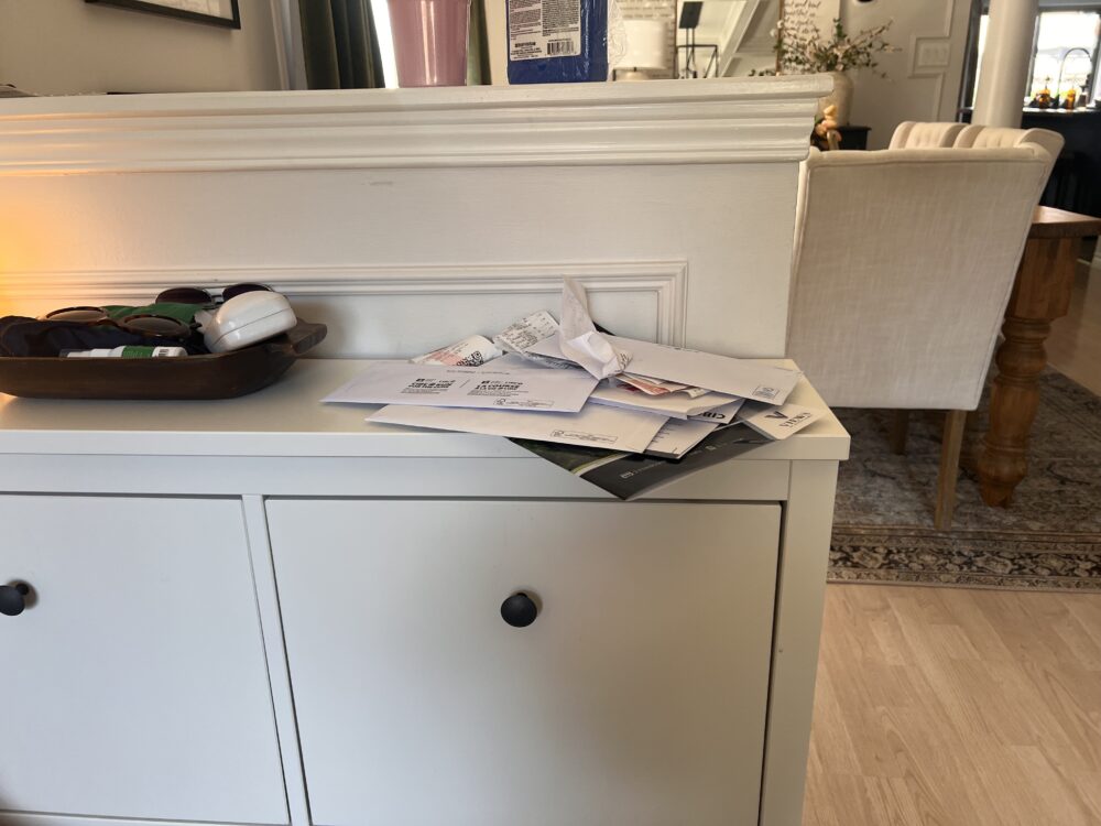 messy mail pile in entryway