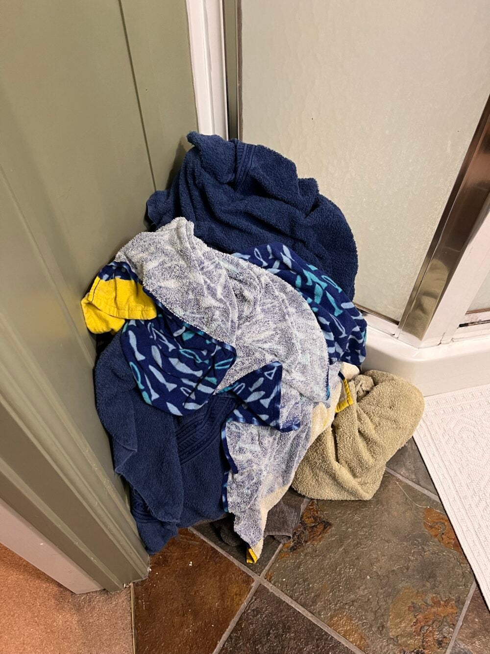 dirty clothes piled on bathroom floor
