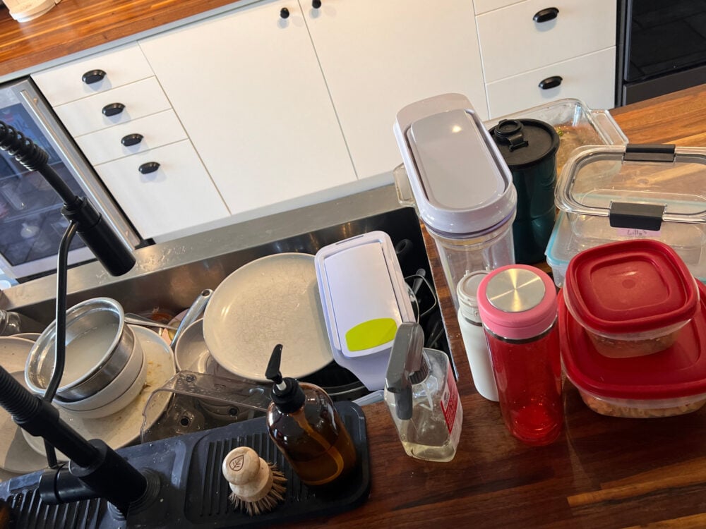 dishes on counter and full sink kitchen