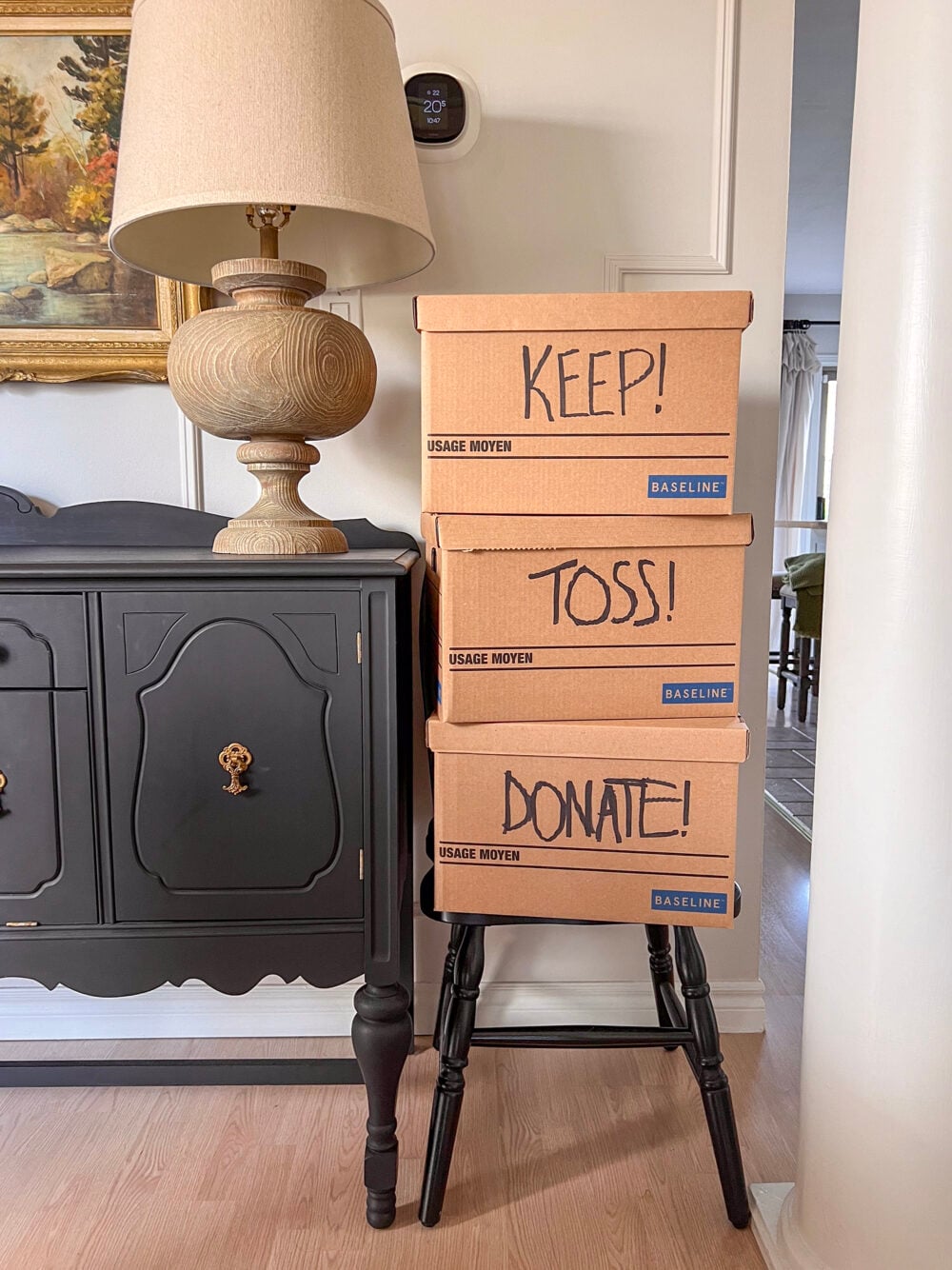 keep toss donate boxes on black Windsor chair in dining room